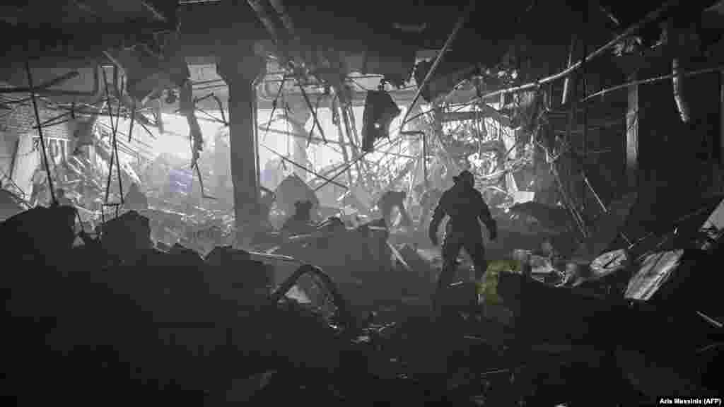 Ukraine -- A Ukranian serviceman walks between debris 