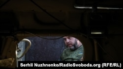 Украинский военнослужащий бригады НГУ "Кара-Даг" осматривает захваченный под Покровском российский БТР-82. 9 октября 2024 года