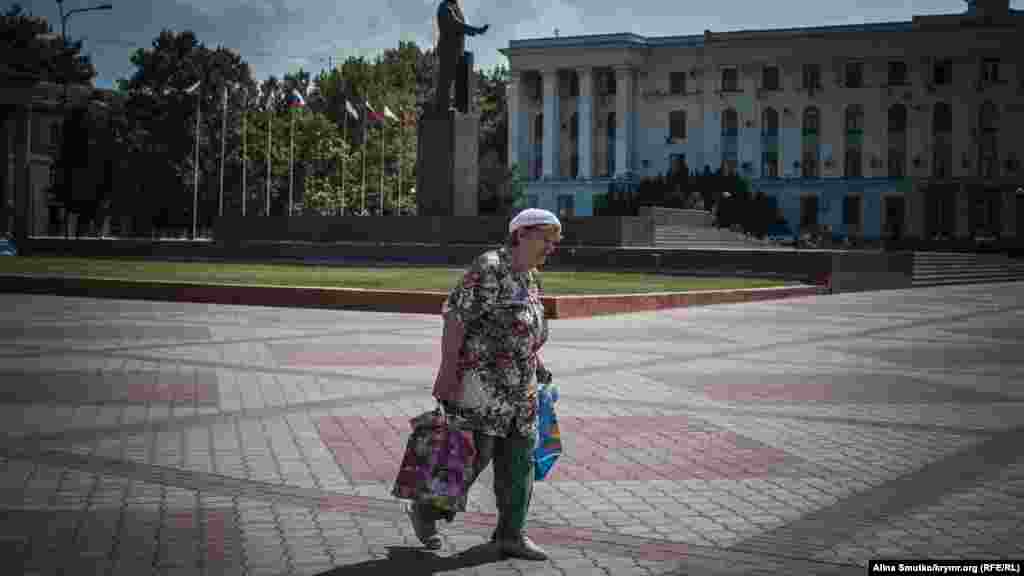 Женщина идет с покупками по площади Ленина&nbsp;