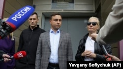 Aleksei Navalny-nin qardaşı Oleg Navalny (solda), həmkarı Ivan Zhdanov (ortada) və Aleksei Navalny-nin həyat yoldaşı Yulia Omskda xəstəxana qarşısında mediaya danışırlar